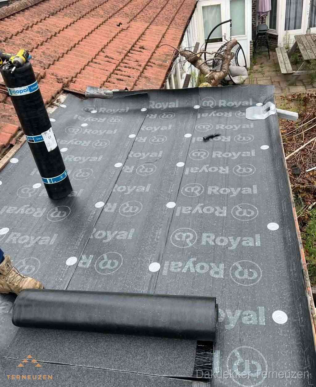 Plat dak met nieuwe bitumen dakbedekking en brandgereedschap in Terneuzen