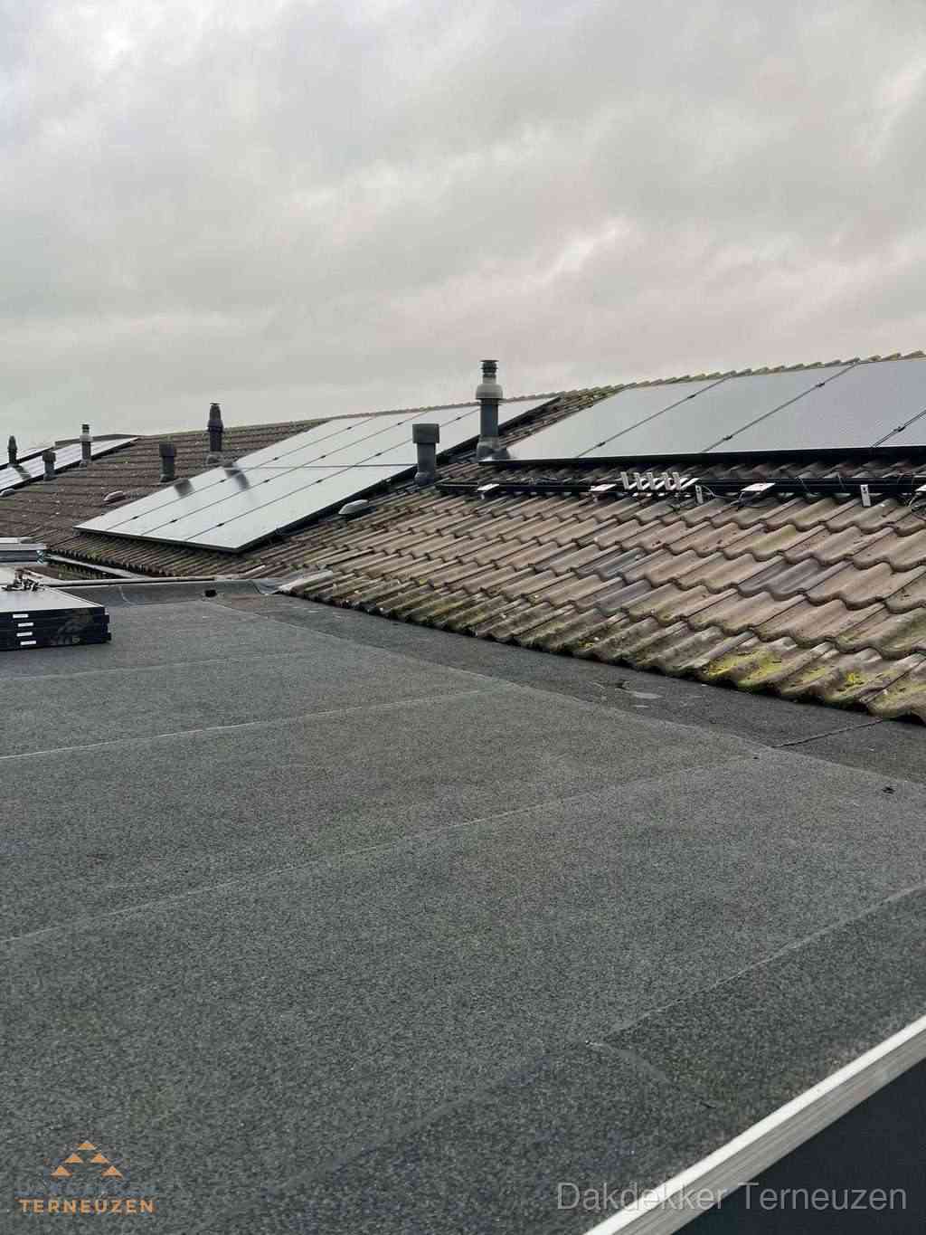 Plat dak inspectie met bitumen bedekking naast schuin pannendak in Terneuzen