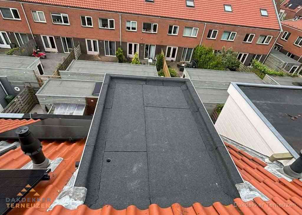 Plat dak met bitumen bedekking naast dakkapel in Terneuzen