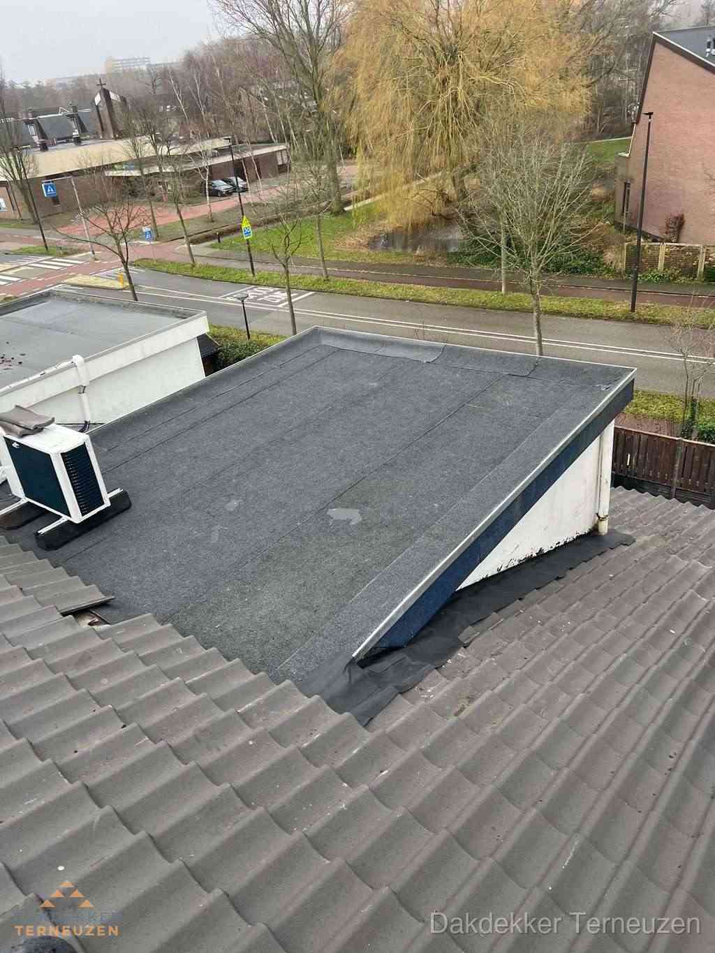 Plat dak met bitumen dakbedekking naast schuin pannendak in Terneuzen