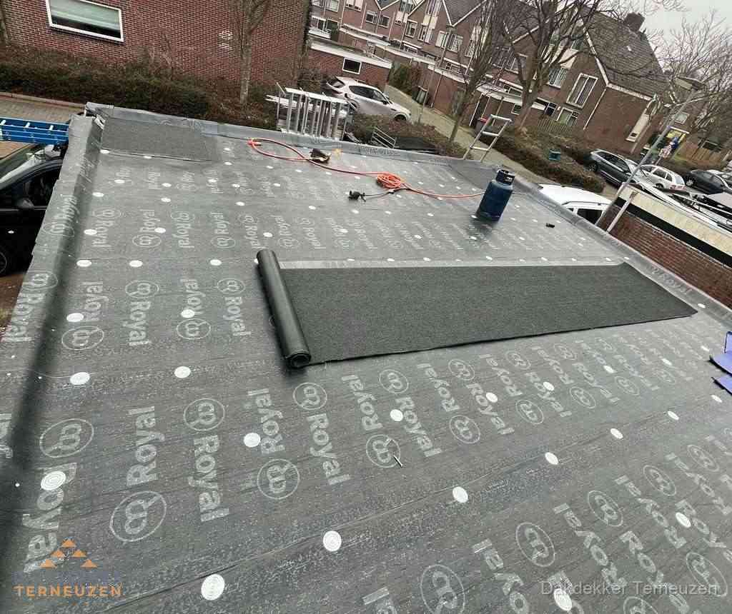 Dakdekker aan het werk met gasbrander op plat bitumen dak in Terneuzen