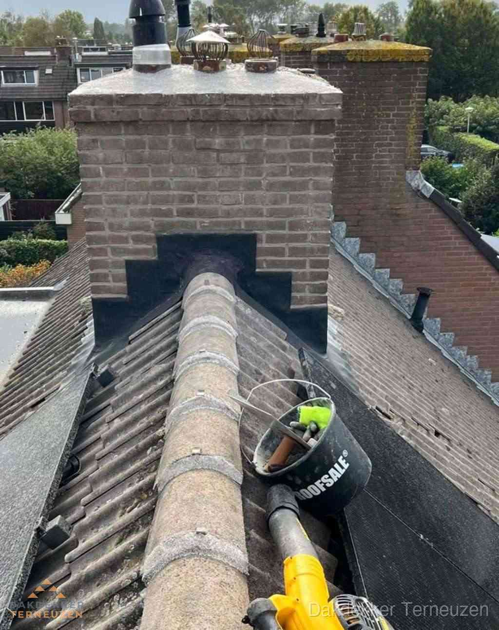 Dakdekker repareert bitumen dakleer bij dakdoorvoer in Terneuzen